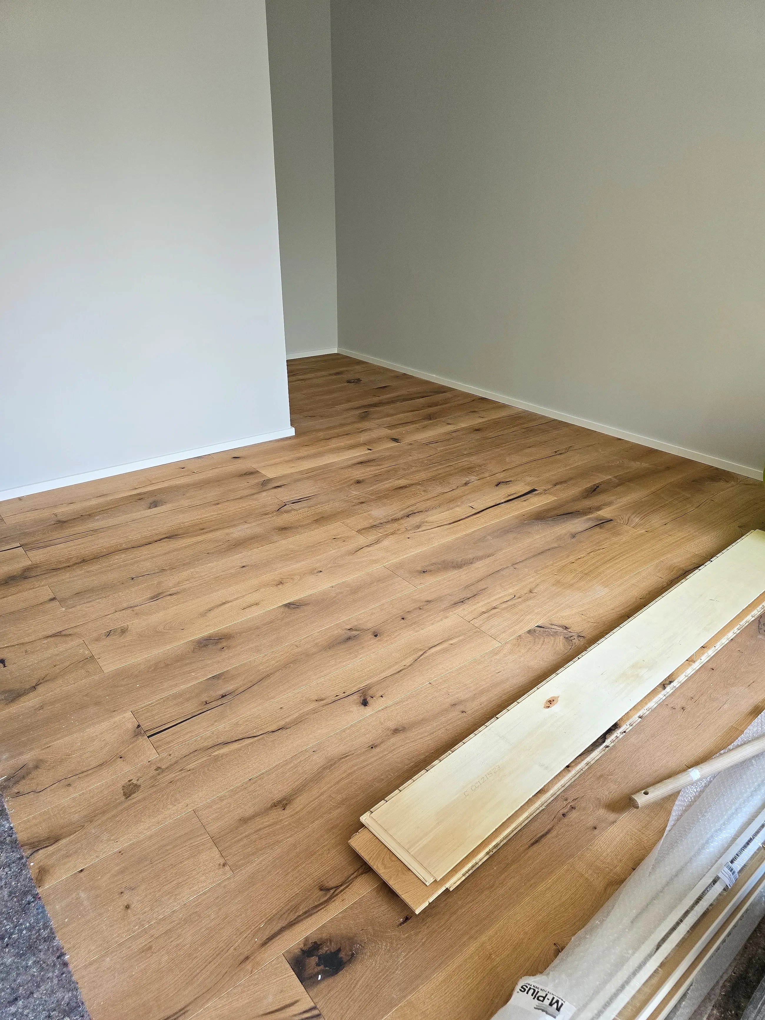 Holzboden während der Verlegung, die letzte Diele liegt noch lose