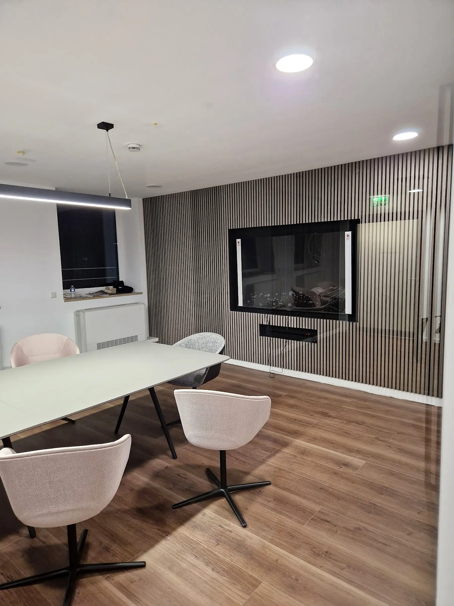 Besprechungsraum mit Lamellenwand, abgehängter Decke und Holzboden