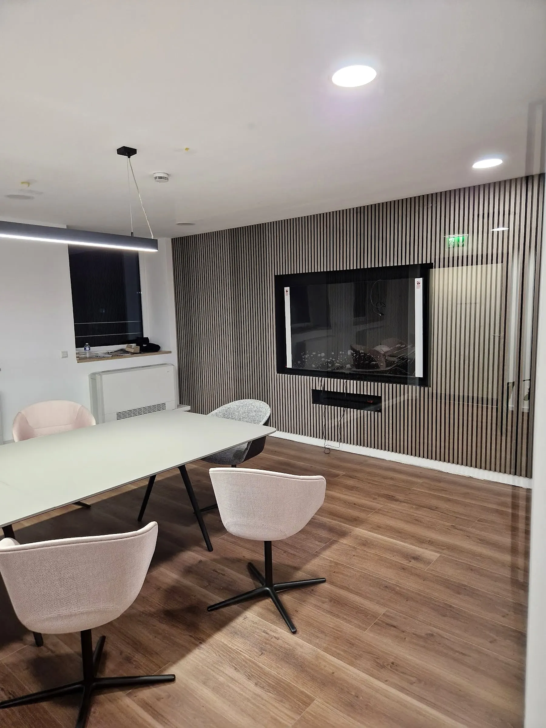 Besprechungsraum mit abgehängter Decke, eingelassenen Spots und Lamellenwand
