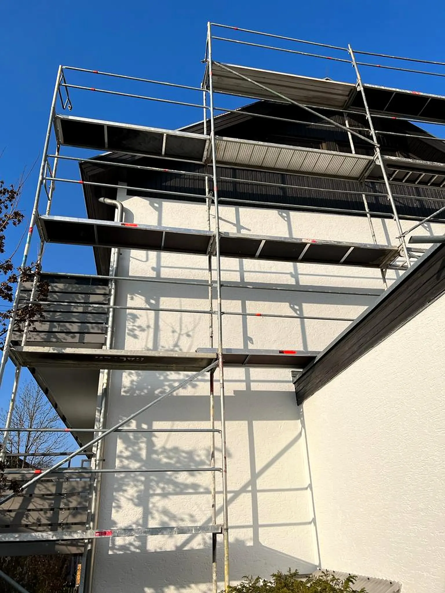 Gerüst an einem Wohnhaus mit hellem Außenputz